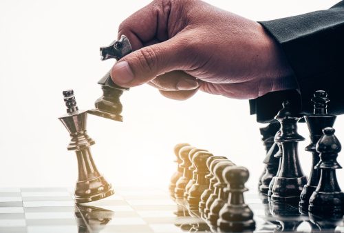 hand of businessman moving chess figure in competition success p